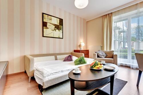 a living room with a bed and a table at Apartamenty Szeroka - Old Town Holidays Home in Gdańsk