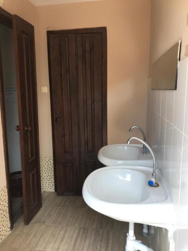 a bathroom with two sinks and a brown door at Svetlana in Lazarevskoye