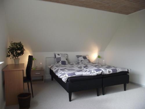 a bedroom with a bed and a table and a chair at Bed and Breakfast Hasseloe in Nykøbing Falster