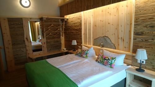 a bedroom with a bed with a wooden wall at Hotel & Auberge le Journal in Sankt Wendel