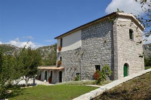 un gran edificio de piedra al lado de una colina en Affittacamere La Casella, en Gallo