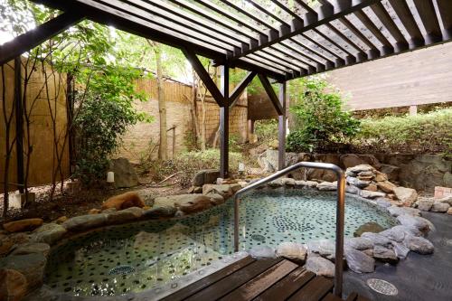 a hot tub in a garden with a wooden deck at Hamilton Ureshino in Ureshino