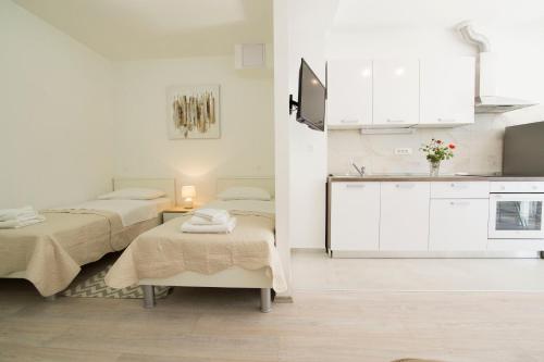 Habitación blanca con 2 camas y cocina en Apartment Neyra 2, en Split