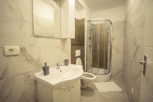 Baño blanco con lavabo y aseo en Apartment Neyra 2, en Split