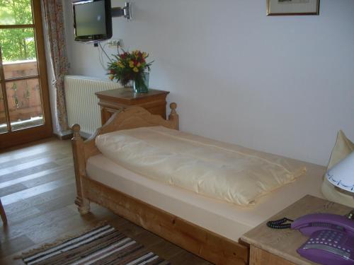 a bed in a room with a tv and a table at Gasthof Ochsenwirt in Oberaudorf