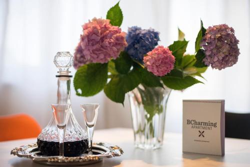 a table with a vase of flowers on a table with a vase at BCharming House in Porto