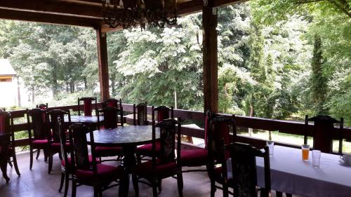 a dining room with tables and chairs and a large window at Pensiunea Mayumi Moneasa in Moneasa