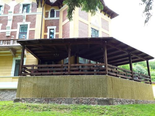a building with a wooden pavilion in front of it at Pensiunea Mayumi Moneasa in Moneasa