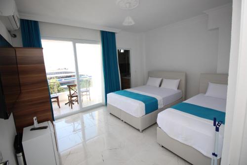 アーブシャ島にあるPegasus Prestijのベッド2台とバルコニーが備わるホテルルームです。