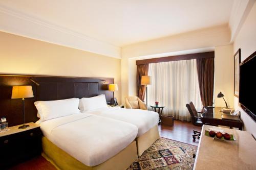 a hotel room with a large bed and a television at Eros Hotel New Delhi, Nehru Place in New Delhi
