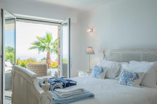 une chambre avec un lit blanc avec vue sur l'océan dans l'établissement Villa Palm, au Trayas