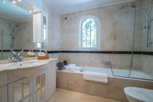 une salle de bain avec une baignoire, un lavabo et des toilettes dans l'établissement Villa Palm, au Trayas