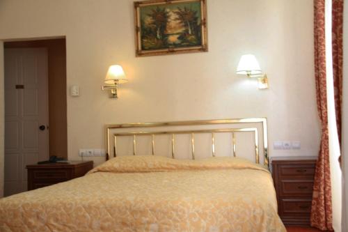 a bedroom with a bed and two lights on the wall at Avra Spa Hotel in Loutra Edipsou