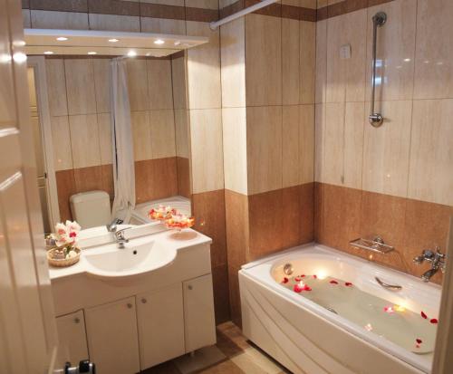 ein Badezimmer mit einer Badewanne, einem Waschbecken und einer Badewanne in der Unterkunft Avra Spa Hotel in Loutra Edipsou
