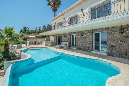 une piscine devant une maison dans l'établissement Villa Palm, au Trayas