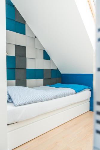 a bed in a room with a striped wall at Apartament Rewa in Rewa