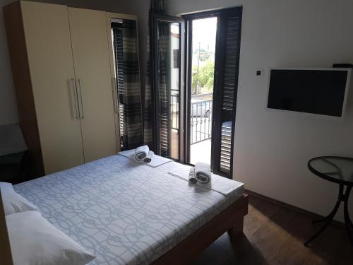 a bedroom with a bed and a balcony with a television at Guest House Sombrero in Senj