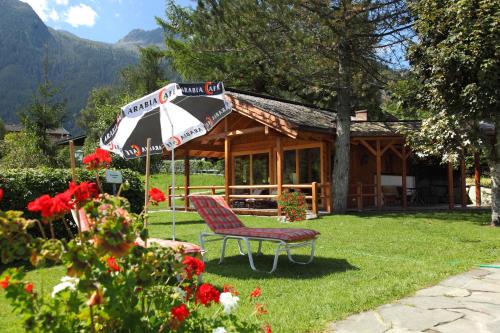 a bench and an umbrella in front of a house at Hotel Krimmlerfälle in Krimml
