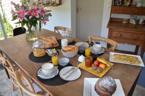 een houten tafel met ontbijtproducten erop bij Ô Sources in Bazenville
