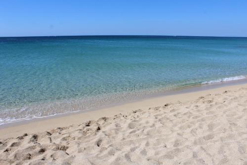 a sandy beach with the ocean in the background at La Buona Creanza by Jdvacanze in Manduria