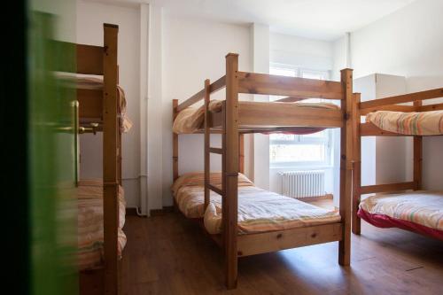 a room with three bunk beds and a window at Albergue de Sabero in Sabero