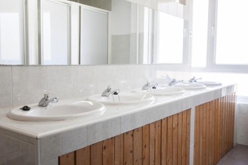 a bathroom with four sinks and a large mirror at Albergue de Sabero in Sabero
