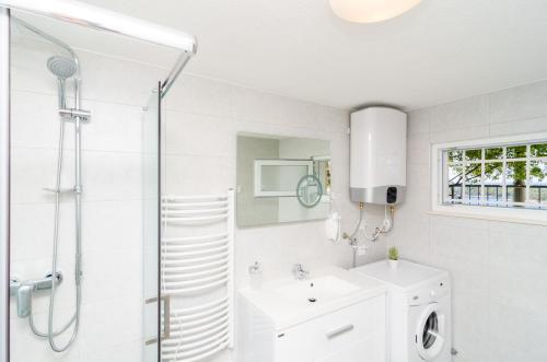 a white bathroom with a sink and a shower at Apartments Shining Star in Dubrovnik