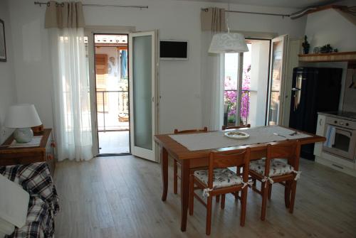 une cuisine avec une table et des chaises ainsi qu'une salle à manger dans l'établissement Casa Fanny, à Limone sul Garda