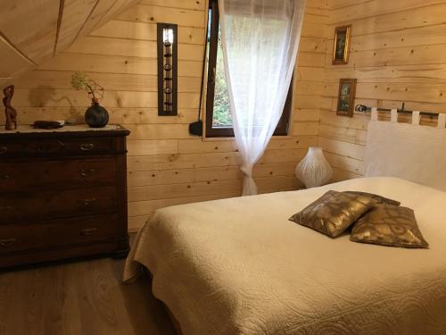 une chambre avec un lit, une commode et une fenêtre dans l'établissement Chalet du champs des semeaux, à Wisches