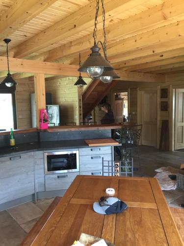 a kitchen with a wooden ceiling with a table at Chalet du champs des semeaux in Wisches