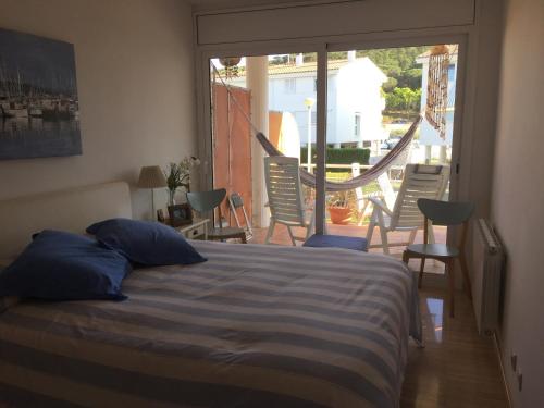 a bedroom with a bed and a balcony with chairs at Blue Ocean in Platja d'Aro