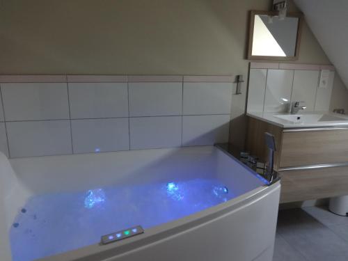 a bathroom with a tub and a sink at Au Coeur des Caps in Audinghen