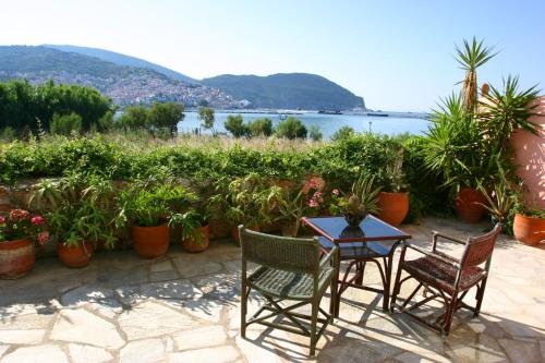 un patio con mesa, sillas y plantas en Spitalia Studios, en Skopelos Town