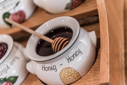 a tea pot with a wooden spoon in a cup of coffee at Hotel Riedl in Kössen