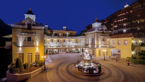 duży budynek z fontanną przed nim w obiekcie Wellnessresidenz Alpenrose w mieście Maurach