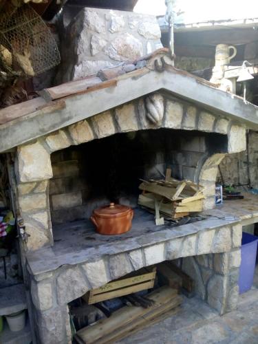 an outdoor brick oven with a pot in it at Apartman i Sobe Čule Cres in Cres