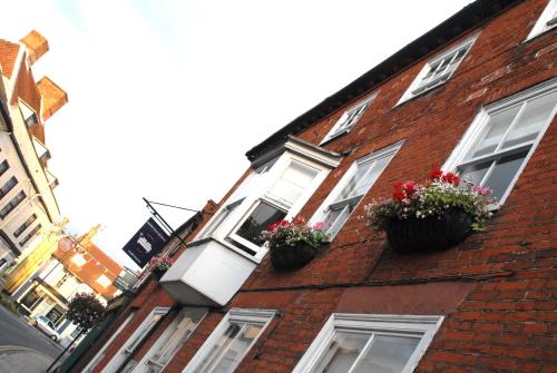 a red brick building with two windows with flowerpots at Short Stay Bungay in Bungay