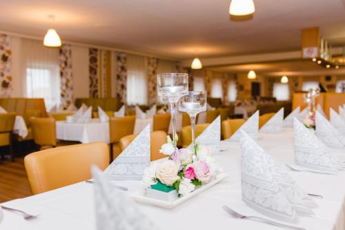 - une table avec des verres à vin et des fleurs dans l'établissement Frühstückspension Scharinger Hof, à Gilgenberg am Weilhart