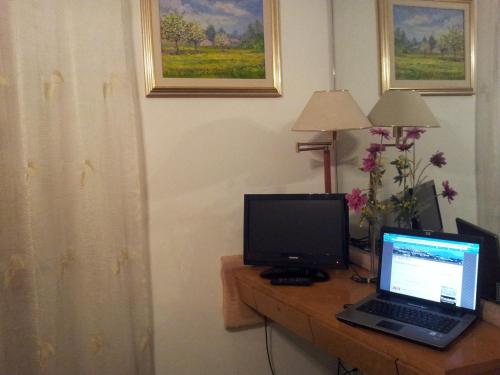 a desk with a laptop and a computer monitor on it at Hotel Post in Bergamo