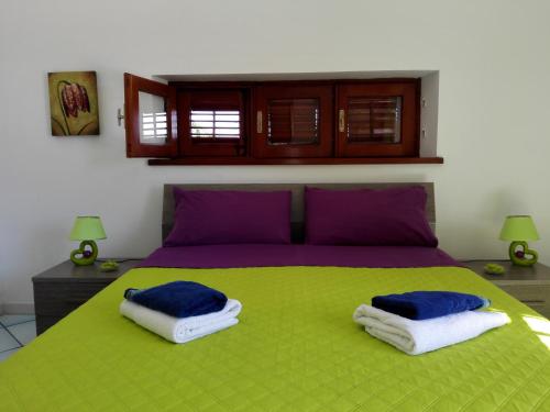 a bedroom with a green bed with two pillows on it at Villa Modus Vivendi in Cinisi