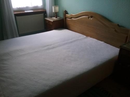 1 dormitorio con 1 cama grande con colcha blanca en Gudrun Waegner, en Welcherath