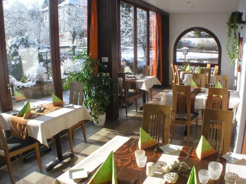 a dining room with tables and chairs and windows at Landhotel Rebstock in Oberkirch