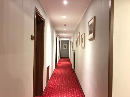 a corridor with a red carpet down a hallway at Hotel San Giorgio in Udine