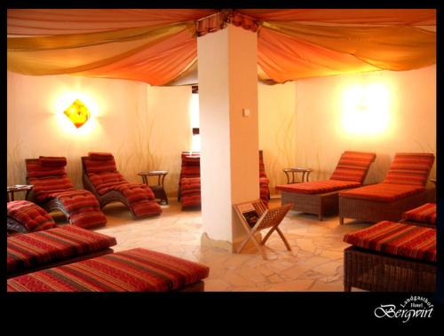 a room with red chairs and a tent at Hotel Bergwirt in Herrieden