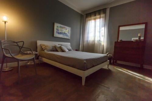 a bedroom with a bed and a mirror and a chair at Villa Niccoli in Castelfiorentino
