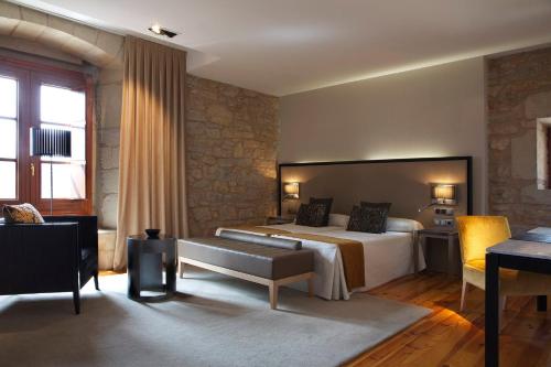 a hotel room with a bed and a desk at Hospedería Palacio de Allepuz in Allepuz