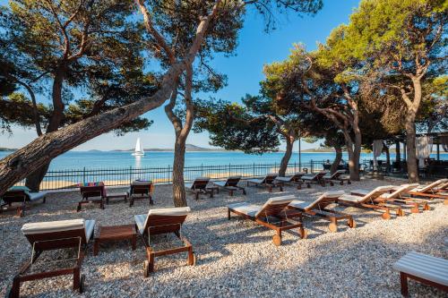 a row of chairs and trees on the beach at Villas Arausana & Antonina in Vodice