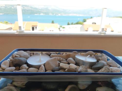 a tray filled with rocks and candles in a window at Apartments Filippi in Korčula