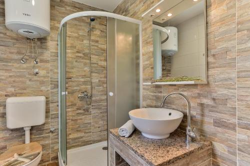 a bathroom with a sink and a glass shower at Apartments Dora Victoria Dream in Medulin