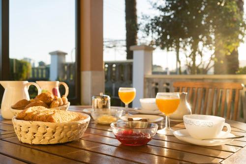 einem Holztisch mit Frühstückszutaten und Gläsern Orangensaft in der Unterkunft Casa Marino Pensión ** in Villapedre